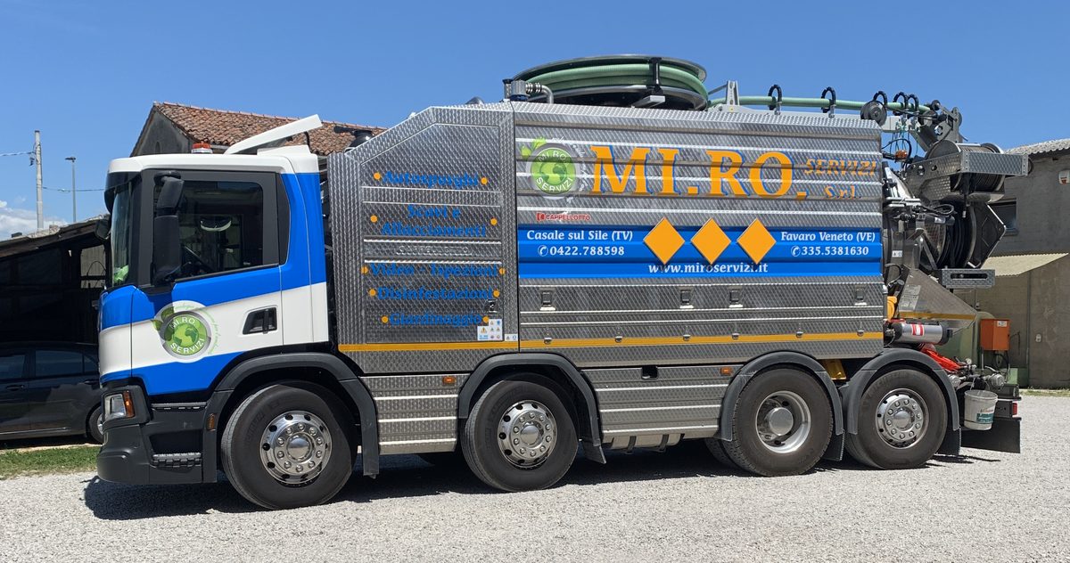 Autospurgo a quattro assi della MI.RO. Servizi: sulla fiancata l'elenco dei servizi — autospurghi, scavi e allacciamenti, video-ispezioni, disinfestazioni, giardinaggio
